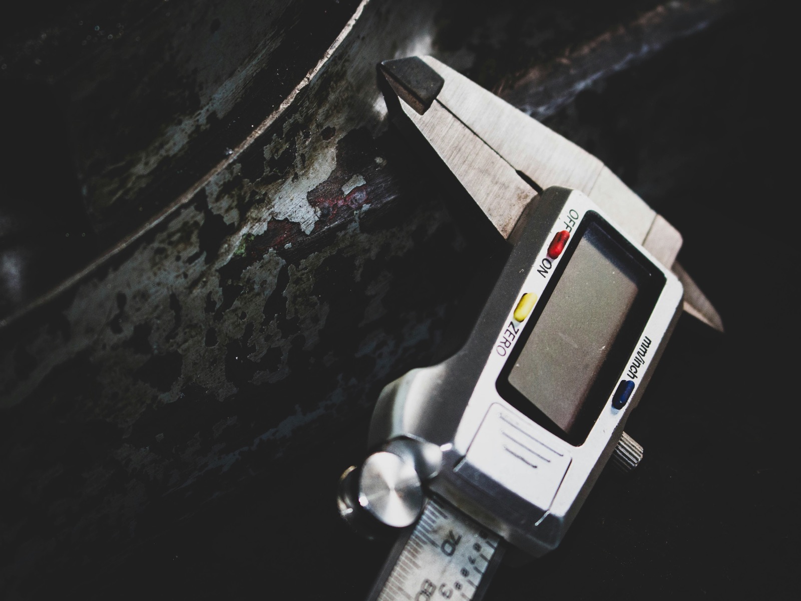 Digital calipers measuring a worn metal component